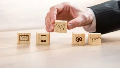 Peças de madeira com diferentes canais de comunicação representando o serviço de atendimento ao cliente