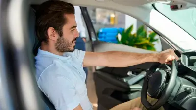 Homem sentado ao volante de um veículo, representando retenção de clientes.