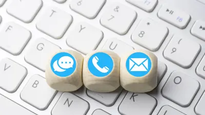 Icones de canais de atendimento ao cliente como chat email e telefone em cima de um teclado de computador.